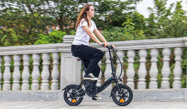 Femme chevauchant un vélo électrique M1pro sur un pont