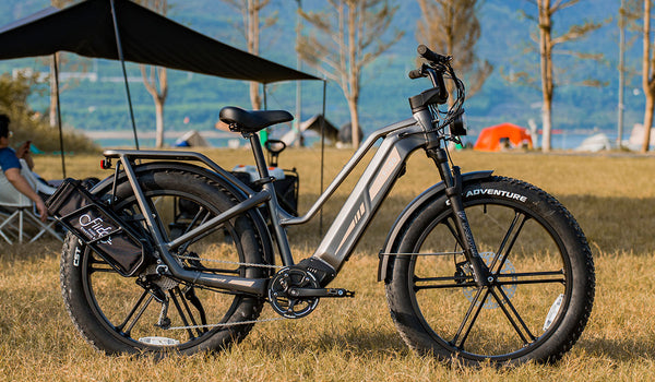 Le vélo électrique Fiido Titan garé dans une zone de camping herbeuse