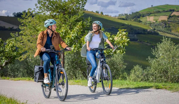 Un homme et une femme discutent en conduisant des vélos électriques Fiido.