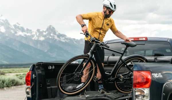 Un homme place un vélo électrique Fiido C21 dans la caisse d'un camion