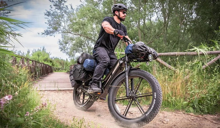 Un homme conduit un vélo électrique Fiido Titan à travers les montagnes