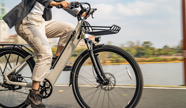 Femme chevauchant un vélo électrique Fiido C11 au bord du lac