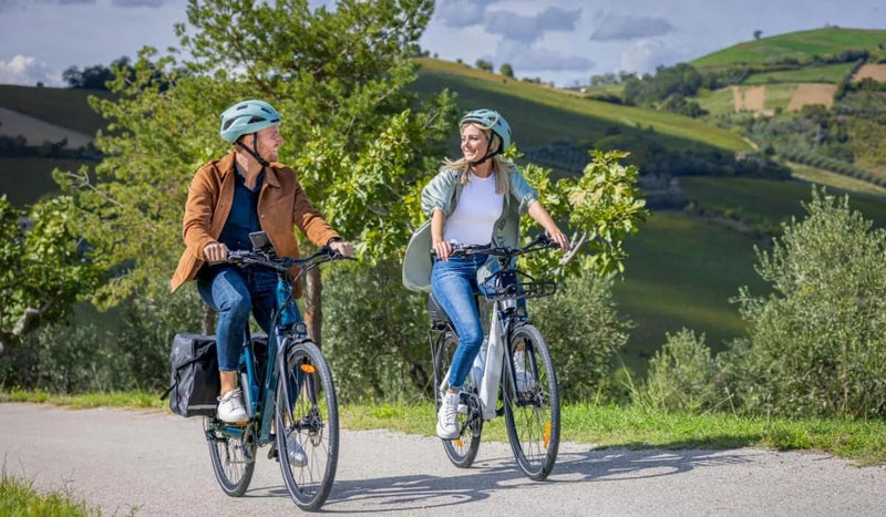 Un homme et une femme sur des vélos électriques Fiido C11 sur la route