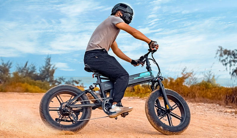 Homme chevauchant un vélo électrique Fiido M1pro sur le sable