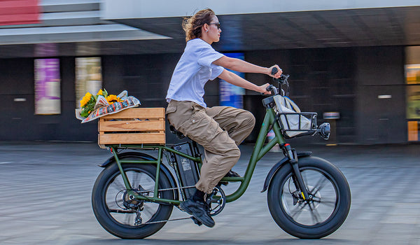 Une cycliste traverse rapidement une zone urbaine sur son Fiido T1Pro