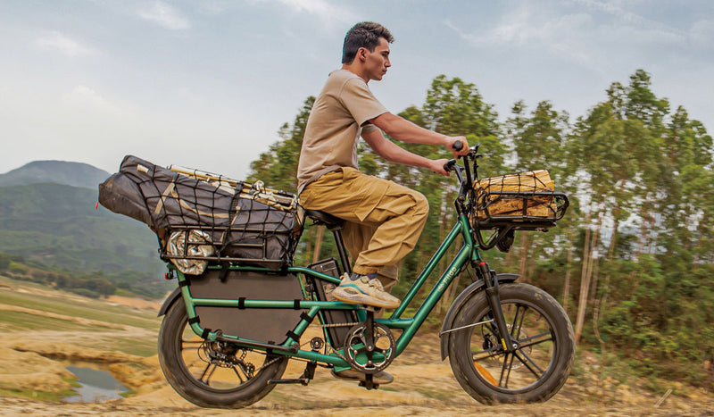 Homme monté sur un vélo électrique Fiido T2 transportant des outils de camping