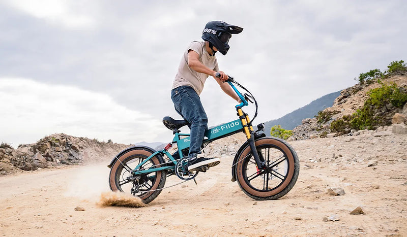 Homme conduisant un vélo électrique Fiido M1 Pro amélioré sur le sable