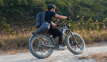 Pilote sur un vélo électrique Fiido Titan, s'attaquant aux sentiers hors route.