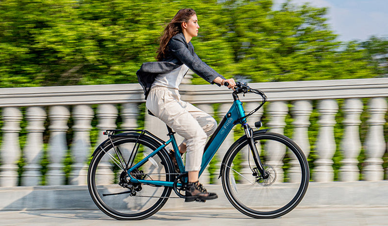 Femme faisant du vélo électrique au bord du lac