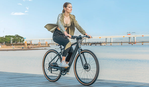 Femme faisant du vélo électrique au bord du lac