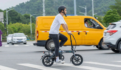 Un homme traverse la route sur un vélo électrique Fiido L3