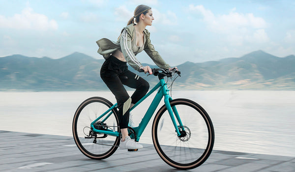 Femme faisant du vélo électrique au bord du lac