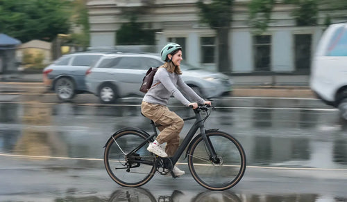 Une femme se rend au travail à vélo électrique léger Fiido C21.