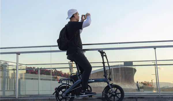 Un homme regarde le coucher de soleil sur le vélo électrique Fiido L3