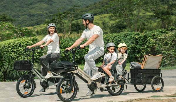 Un homme roule avec un T3 Max Cargo E-Bike en transportant son enfant.