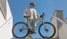 Un homme roule en vélo électrique Fiido Air en carbone dans la ville.