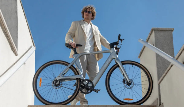 Un homme roule en vélo électrique Fiido Air en carbone dans la ville.