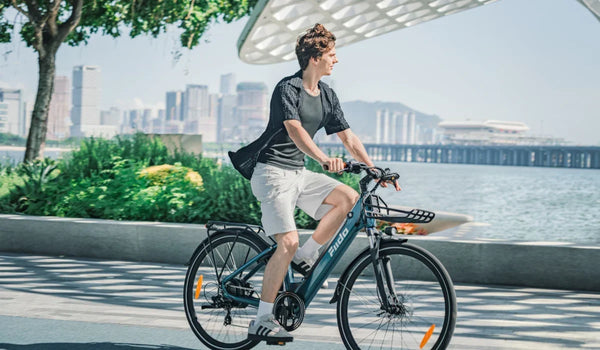 Vélo électrique urbain Fiido C11 Pro avec un homme à son guidon par une journée ensoleillée.