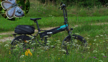 Un vélo électrique Fiido M1 Pro à pneus larges a été temporairement posé dans l’herbe.