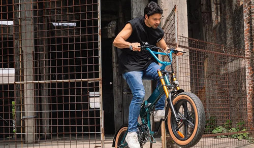 Un homme conduit un VTT électrique Fiido M1 Pro sur un sentier de montagne.