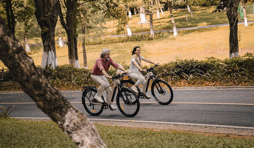 Deux cyclistes sur des vélos électriques de randonnée Fiido Nomads Pro sur une route urbaine