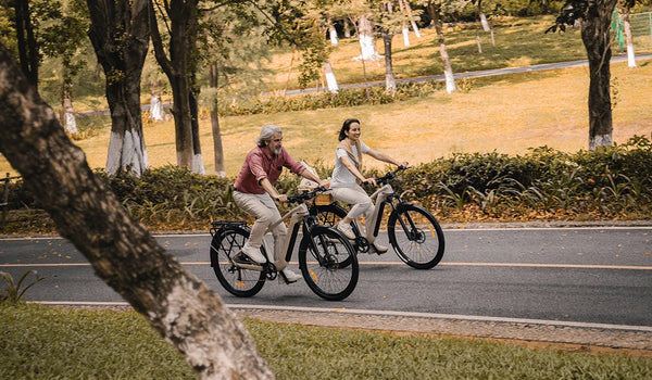 Deux cyclistes sur des vélos électriques de randonnée Fiido Nomads Pro sur une route urbaine