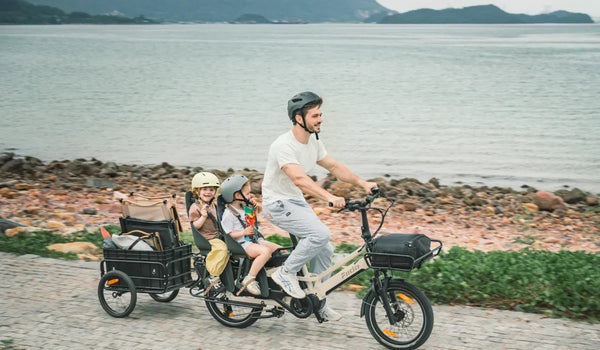 Vélo électrique cargo longtail Fiido T3 Max transportant des enfants avec un homme à vélo par une journée ensoleillée