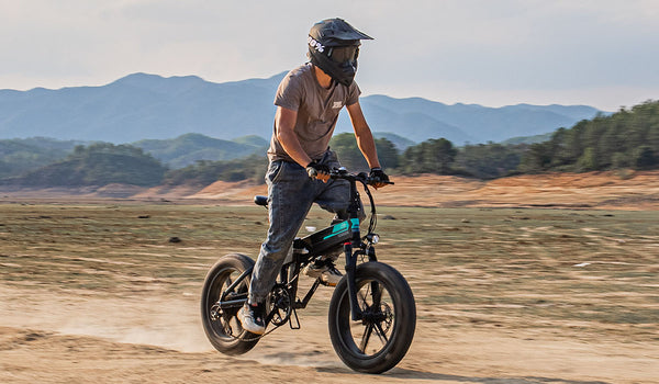 Homme faisant du vélo électrique sur le sable